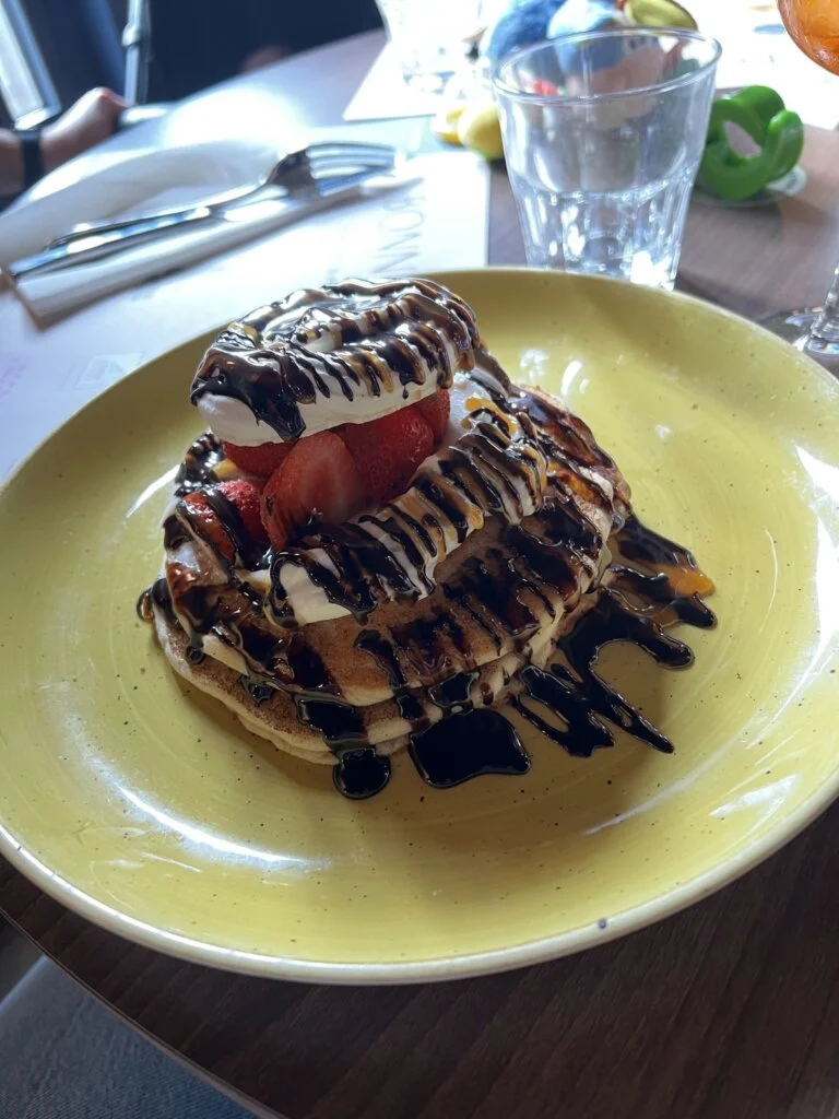 Pancakes with chocolate sauce on yellow plate
