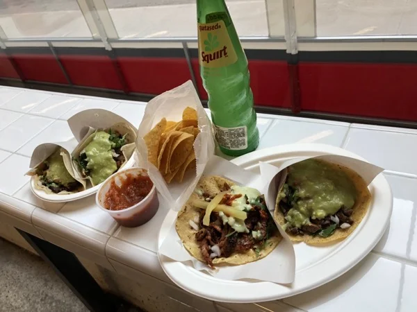 Tacos and chips on white table