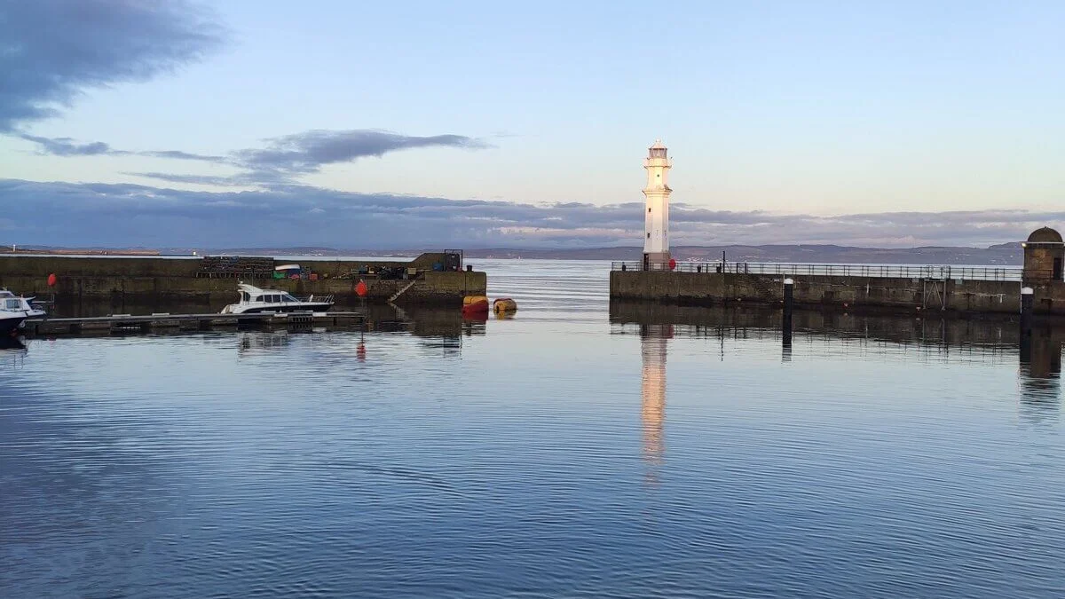 View of sea in harbour with lighthouse